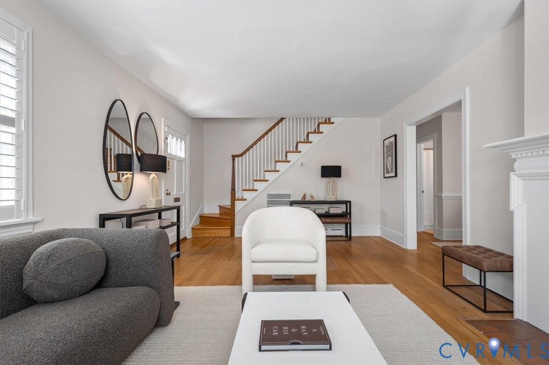 613 Maple Avenue, Near West End, Richmond, VA 23226 Hardwood flooring, painted white staircase with wood handrail, white interior shutters, white trim, and a white fireplace mantel