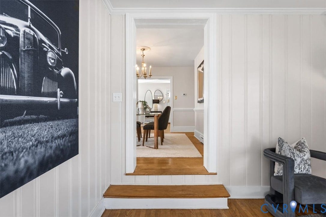 613 Maple Avenue, Near West End, Richmond, VA 23226 Hardwood flooring, painted vertical paneling, crown molding, and a cased doorway with a threshold