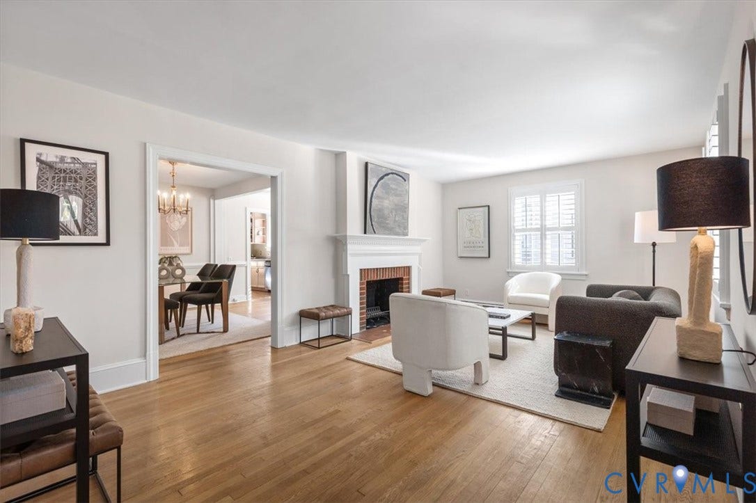 613 Maple Avenue, Near West End, Richmond, VA 23226 Hardwood flooring, white painted walls, a traditional fireplace with a white mantel, and white window shutters
