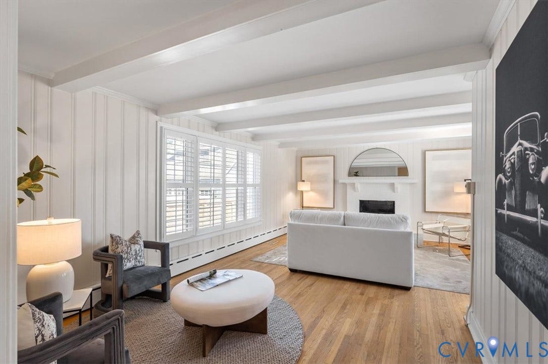 613 Maple Avenue, Near West End, Richmond, VA 23226 Wood-finish flooring, white paneling, white exposed beam ceiling, plantation shutters, and a fireplace with mantel