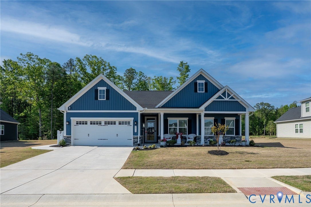 8073 Winter Fog Drive, Spring Elm, New Kent, VA 23124 Single-story residence featuring blue siding, white trim, a covered front porch, and a two-car garage