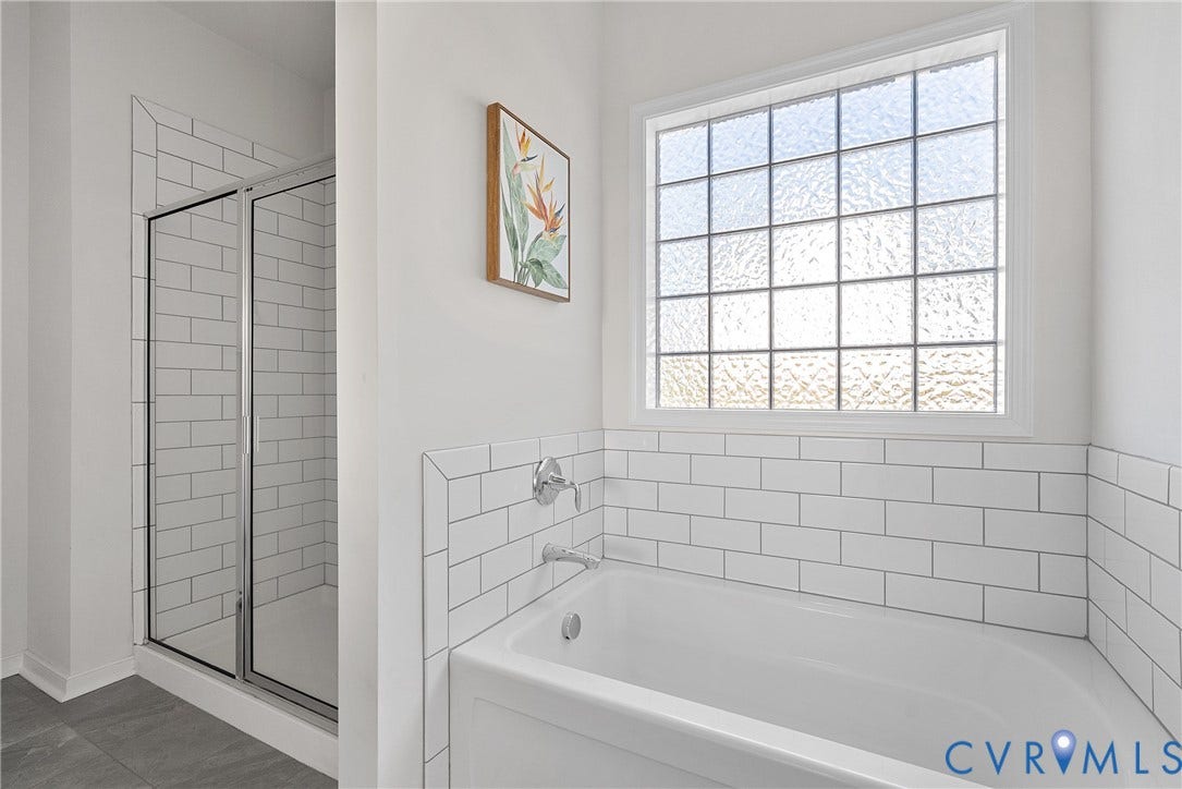 1605 Reed Marsh Place, Reed Marsh, Goodview, VA 23063 Bathroom featuring a white subway tile surround, a built-in bathtub with chrome fixtures, a separate glass-enclosed shower, a privacy window.