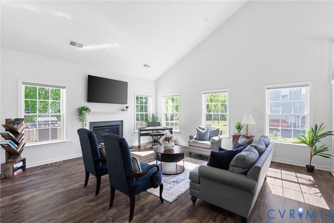 1605 Reed Marsh Place, Reed Marsh, Goodview, VA 23063 Spacious living room featuring vaulted ceilings, wood-finish flooring, a fireplace with a white mantel, and multiple large windows delivering loads of light.