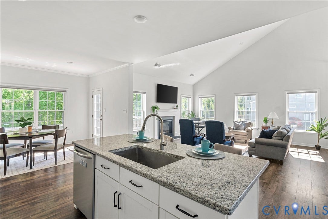 1605 Reed Marsh Place, Reed Marsh, Goodview, VA 23063 Open-concept kitchen and dining area featuring wood-finish flooring, white cabinetry, a central island with a granite countertop, and stainless steel appliances.