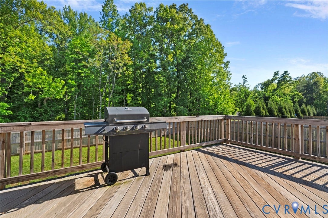 1605 Reed Marsh Place, Reed Marsh, Goodview, VA 23063 Spacious wood deck with natural wood railing overlooking a lush green backyard, backing up to private woods.