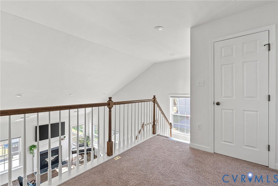 1605 Reed Marsh Place, Reed Marsh, Goodview, VA 23063 Carpeted loft space featuring a wood and white spindle railing overlooking a lower level
