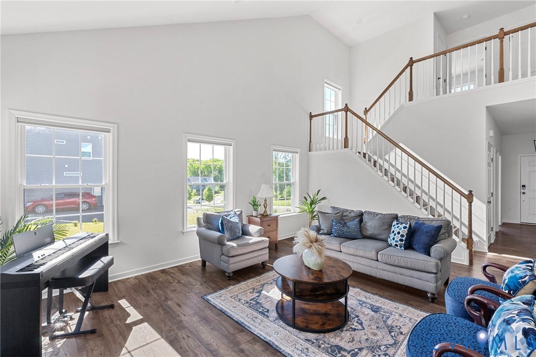 1605 Reed Marsh Place, Reed Marsh, Goodview, VA 23063 Spacious living room featuring vaulted ceilings, wood-finish flooring, a fireplace with a white mantel, and multiple large windows delivering loads of light.