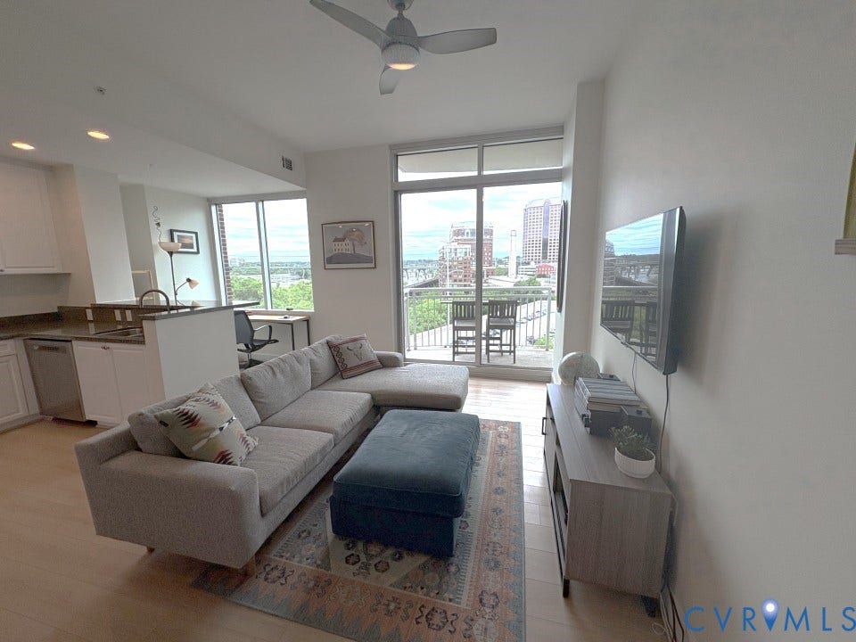 301 Virginia Street, #U804, Downtown, Richmond, VA 23219 Living Room opens to Kitchen, Office, Dining Area and balcony and has hardwood floors and ceiling fan.