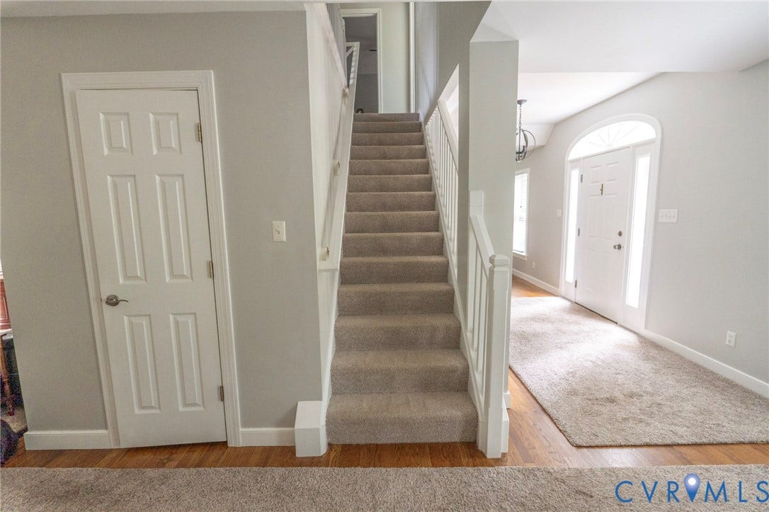 1670 Mill Quarter Road, Powhatan, VA 23139 Bright, open foyer featuring a grand staircase with neutral-toned carpeting and white painted railings