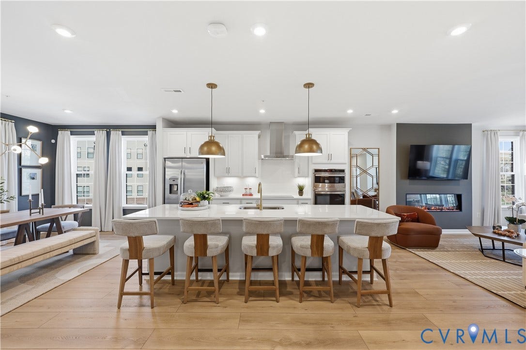 13208 Brattice Loop, 2510, Midlothian, VA 23114 Open-concept living area featuring a kitchen island with seating for four, wood-finish flooring, a contemporary fireplace, and recessed lighting