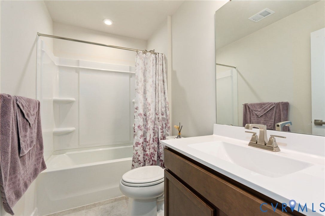 7236 George Wythe Lane, Summer Maple, New Kent, VA 23124 Full bathroom with a white tub and shower combination, a single vanity with a white countertop, and wood-finish cabinetry