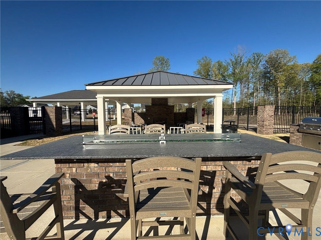 7236 George Wythe Lane, Summer Maple, New Kent, VA 23124 Outdoor entertainment area featuring a large island with a fire pit, brick base, and integrated seating