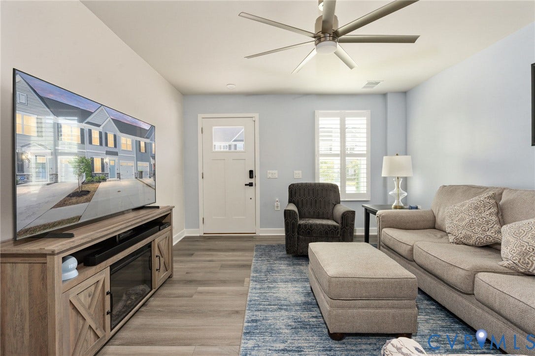 7236 George Wythe Lane, Summer Maple, New Kent, VA 23124 Open-concept living space featuring wood-finish flooring, a modern ceiling fan, and a front entry door with an upper window pane