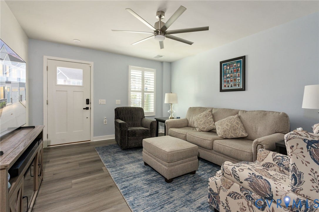 7236 George Wythe Lane, Summer Maple, New Kent, VA 23124 Spacious living area featuring wood-finish flooring, light blue walls, and a multi-blade ceiling fan