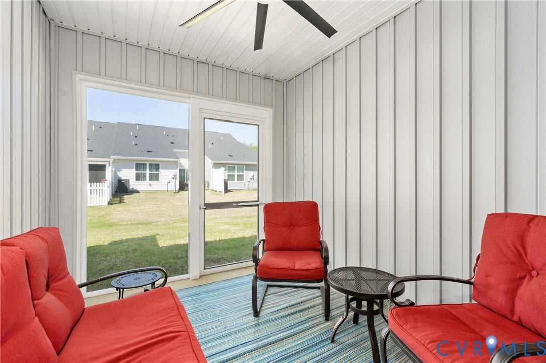 7236 George Wythe Lane, Summer Maple, New Kent, VA 23124 Enclosed porch with white paneled walls and ceiling, featuring a ceiling fan, and sliding glass doors opening to a grassy yard