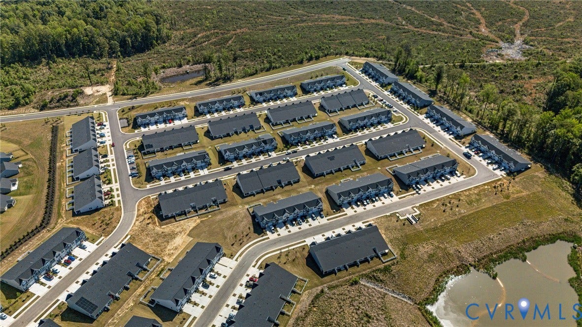 7236 George Wythe Lane, Summer Maple, New Kent, VA 23124 Aerial perspective of a residential development featuring rows of townhomes with dark roofs and light-colored exteriors