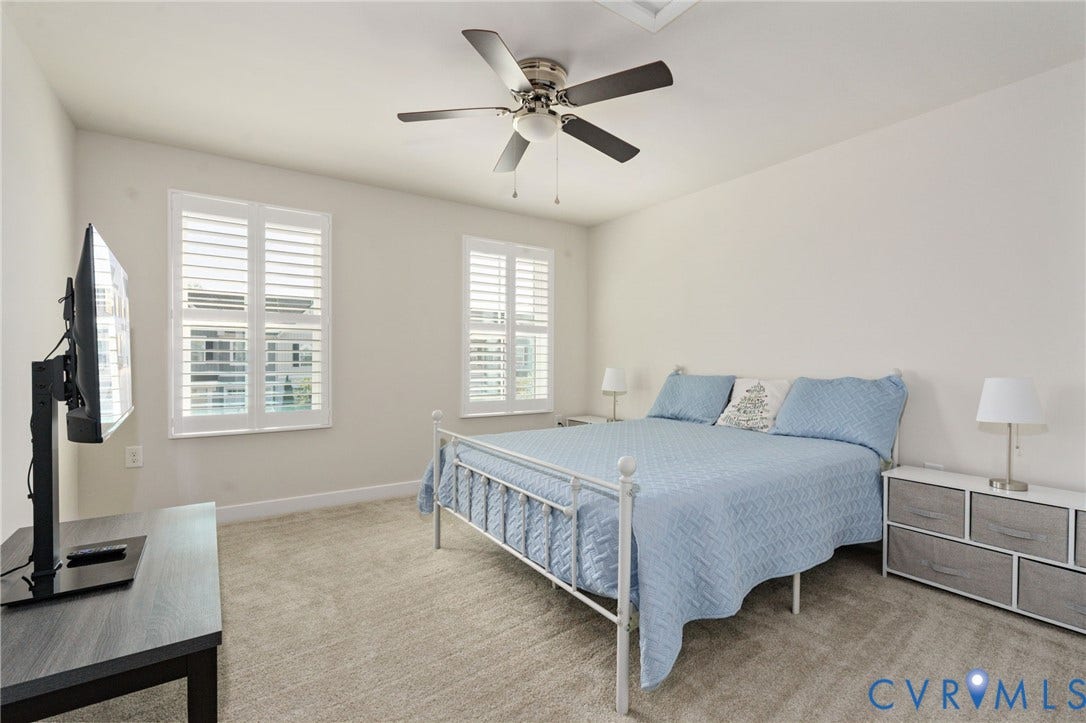 7236 George Wythe Lane, Summer Maple, New Kent, VA 23124 Carpeted room featuring a ceiling fan with light, two windows with white plantation shutters, and light-toned wall paint