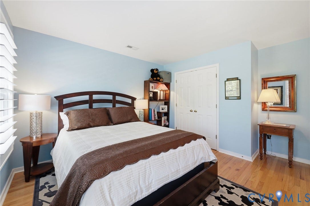 4909 Parsons Walk Place, Twin Hickory, Glen Allen, VA 23059 Bedroom featuring light blue walls, wood-finish flooring, white plantation shutters, and a double-door closet with paneling