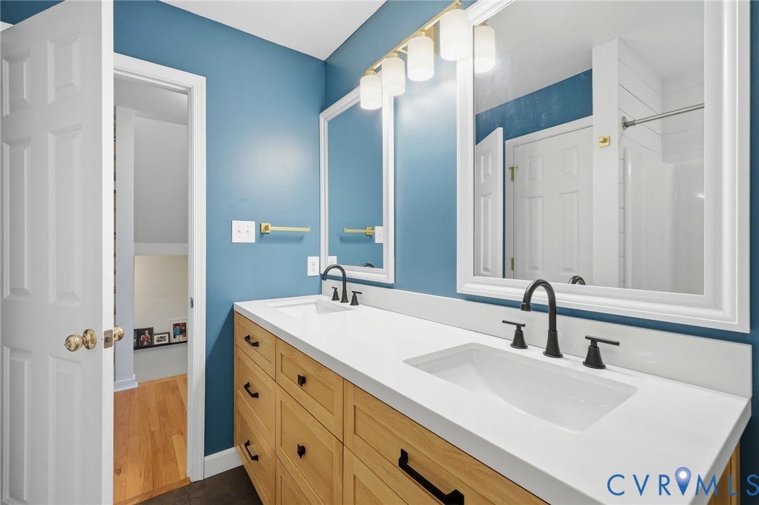 4909 Parsons Walk Place, Twin Hickory, Glen Allen, VA 23059 Dual white undermount sinks set into a white countertop, featuring matte black fixtures and a light wood-finish vanity with ample storage