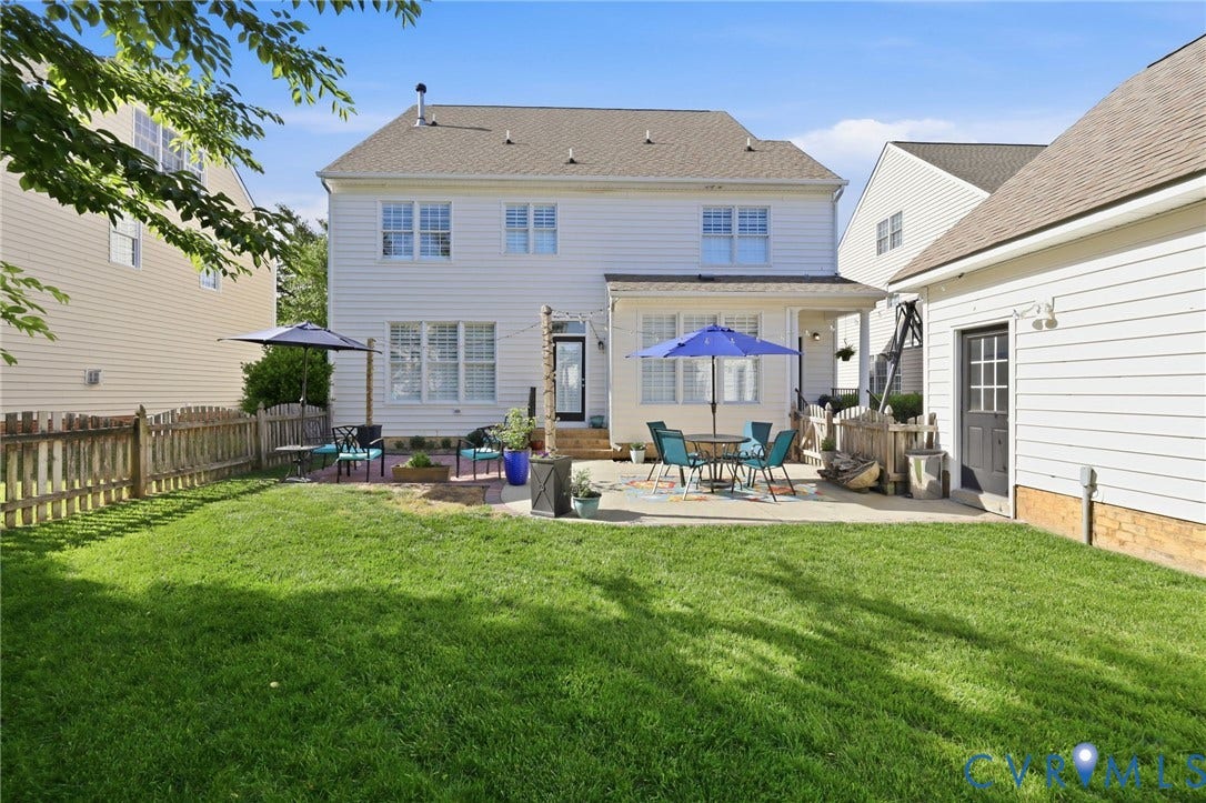 4909 Parsons Walk Place, Twin Hickory, Glen Allen, VA 23059 Expansive backyard featuring a concrete patio, mature lawn, a privacy fence, and a rear exterior with multiple windows