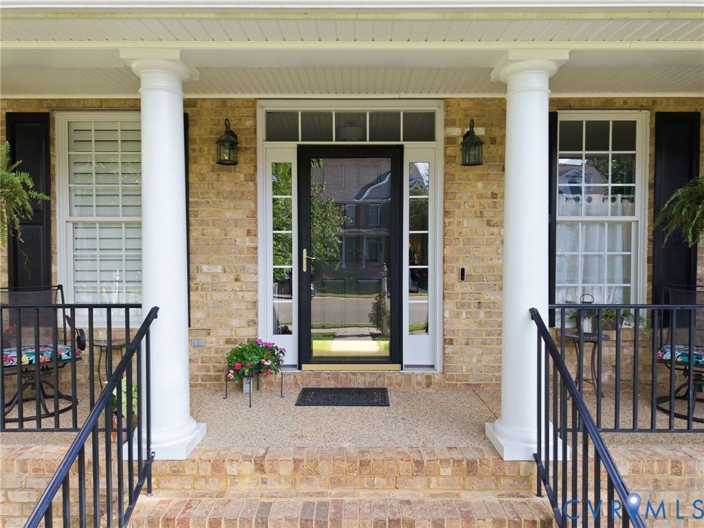4909 Parsons Walk Place, Twin Hickory, Glen Allen, VA 23059 Brick facade with a covered porch featuring two classical columns, black shutters, and a white transom door with sidelights