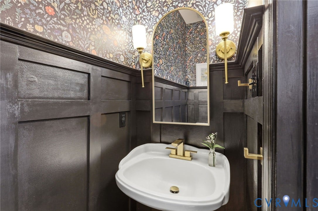 4909 Parsons Walk Place, Twin Hickory, Glen Allen, VA 23059 Pedestal sink with brass-finish faucet, framed by dark wood paneling and floral wallpaper
