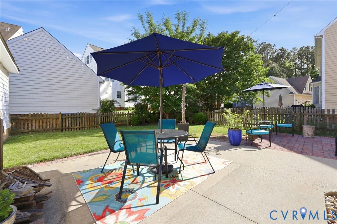4909 Parsons Walk Place, Twin Hickory, Glen Allen, VA 23059 Expansive outdoor patio featuring a concrete main area, a brick paver extension, and a picket fence enclosing a manicured lawn