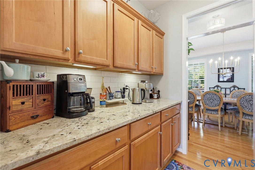 4909 Parsons Walk Place, Twin Hickory, Glen Allen, VA 23059 Kitchen counter space featuring light wood cabinetry with silver hardware, speckled stone countertops, and a white subway tile backsplash