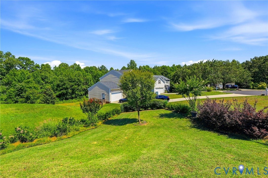 Spacious green lawn surrounding a two-story residence with a two-car garage