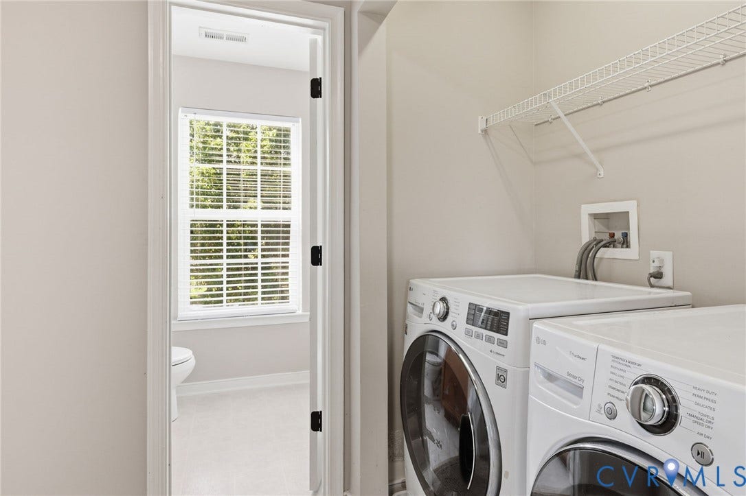Dedicated laundry area featuring a wire storage shelf and connections for a washer and dryer