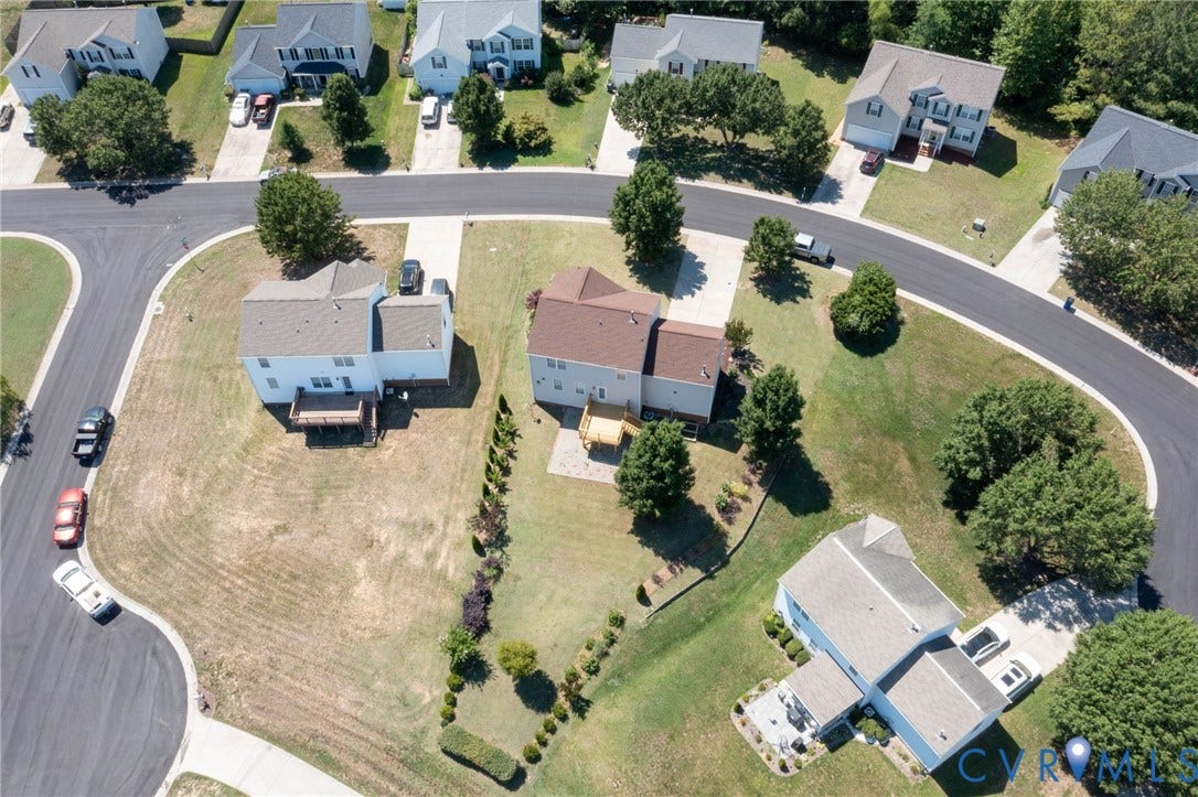Aerial view of a residential community featuring multiple two-story homes with pitched roofs