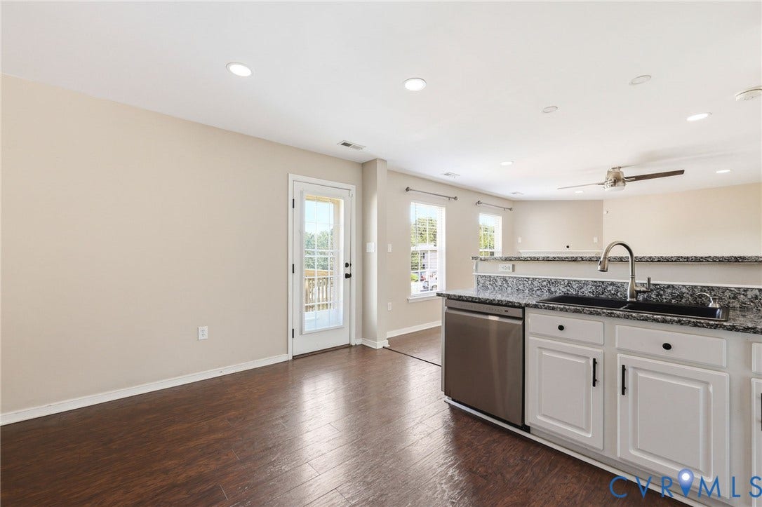 Kitchen featuring white cabinetry, a black sink, a stainless steel dishwasher, and granite-look countertops