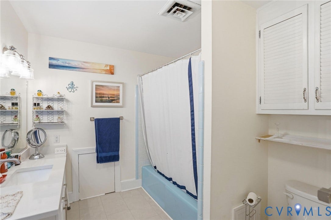 11016 Pridesville Road, Amelia, VA 23002 Bathroom featuring a single vanity with an integrated sink, a built-in bathtub, and overhead cabinetry