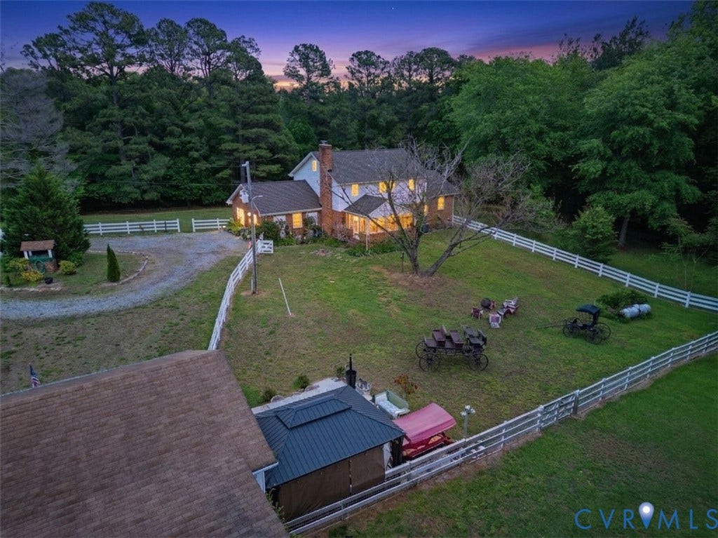 11016 Pridesville Road, Amelia, VA 23002 Expansive property featuring a residence with brick and siding exterior, a separate outbuilding with a metal roof, and a gravel driveway