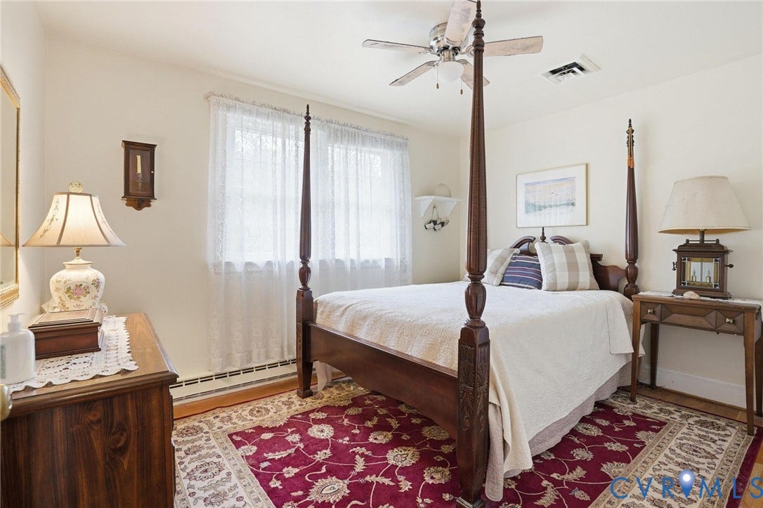 11016 Pridesville Road, Amelia, VA 23002 Light-filled room featuring neutral wall tones, a window with sheer white coverings, and wood-finish flooring partially covered by a patterned area rug