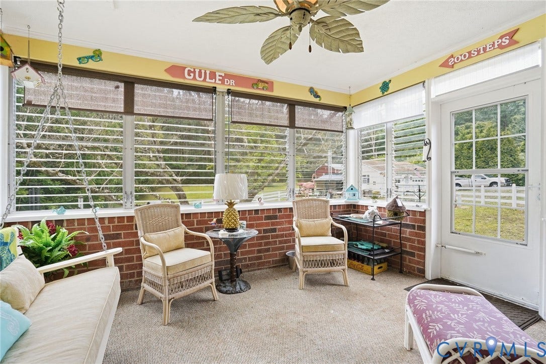 11016 Pridesville Road, Amelia, VA 23002 Enclosed porch with brick half-walls, multiple windows, and a leaf-shaped ceiling fan