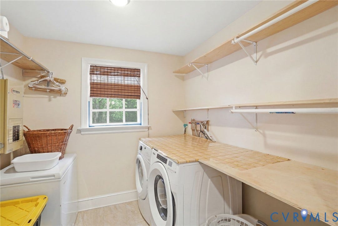 11016 Pridesville Road, Amelia, VA 23002 Dedicated laundry area featuring a large window with natural light, wood-finish shelving, and built-in countertops above appliances