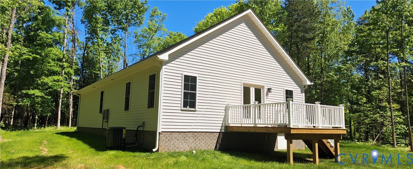 White siding residence featuring an elevated wood deck with white railings, a double-door exterior entry, and multiple windows