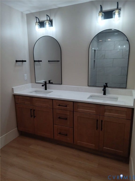 Double vanity featuring wood-finish cabinetry with matte black hardware, white countertops, and dual undermount sinks with matte black faucets