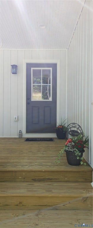 Covered porch entry featuring a dark-colored door with upper window panes