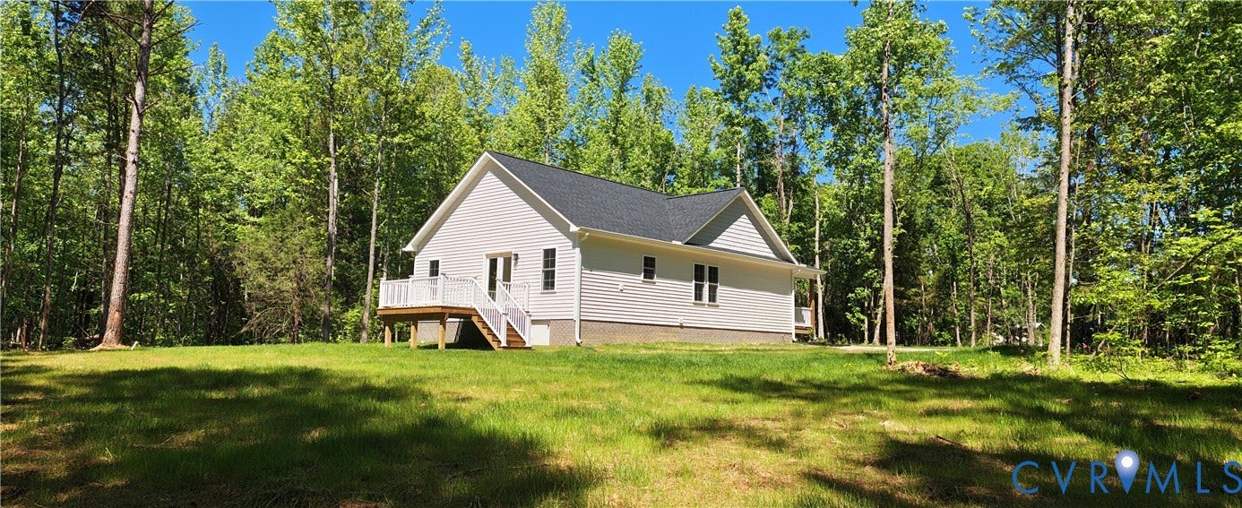 Single-story residence featuring light gray siding, a dark shingle roof, and a rear deck with white railings