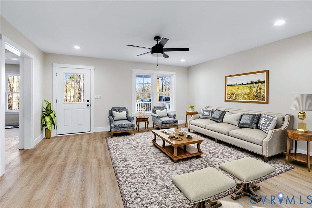 Spacious living area featuring light-toned wood-finish flooring and ample natural light from multiple windows