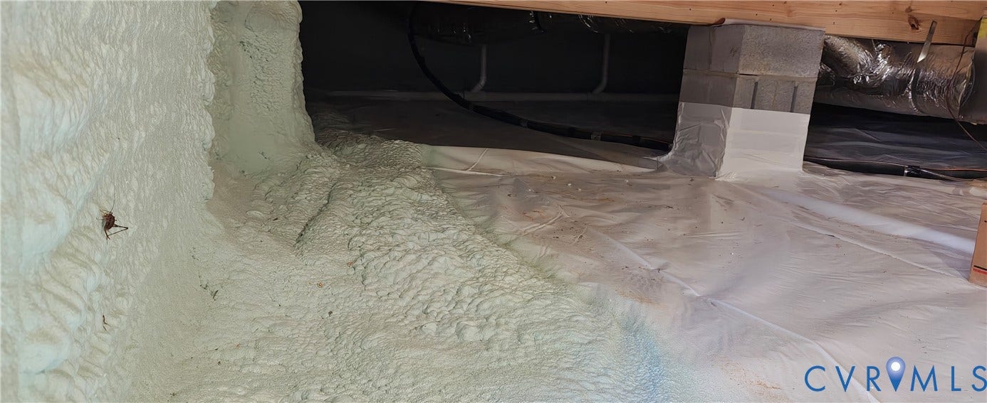 Encapsulated crawl space featuring spray foam insulation and a durable vapor barrier