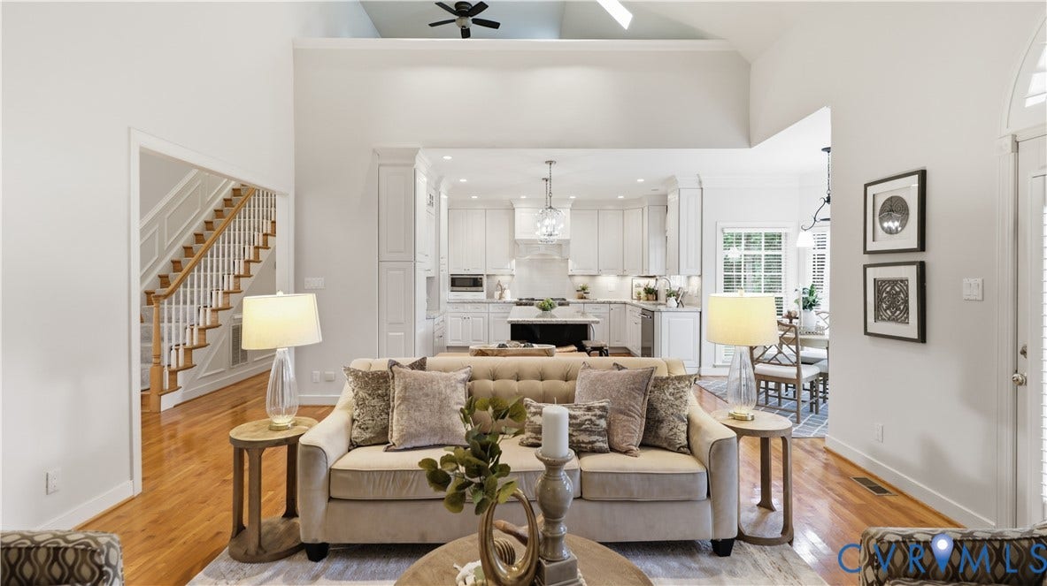 12400 Chadsworth Place, Wyndham, Glen Allen, VA 23059 Open-concept living space featuring vaulted ceilings, wood-finish flooring, a white kitchen with shaker cabinetry, and a dining area with natural light