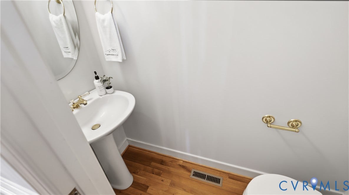 12400 Chadsworth Place, Wyndham, Glen Allen, VA 23059 Pedestal sink featuring brass fixtures and a round mirror
