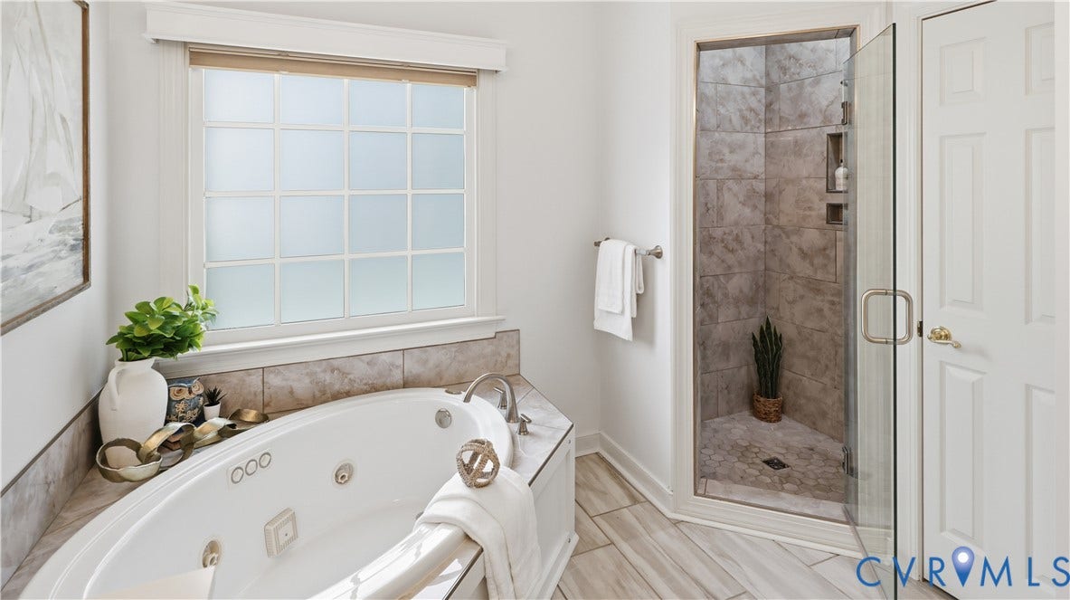 12400 Chadsworth Place, Wyndham, Glen Allen, VA 23059 Soaking tub with a tiled surround, frosted window, and a separate glass-enclosed shower with tiled walls and a pebble-stone floor