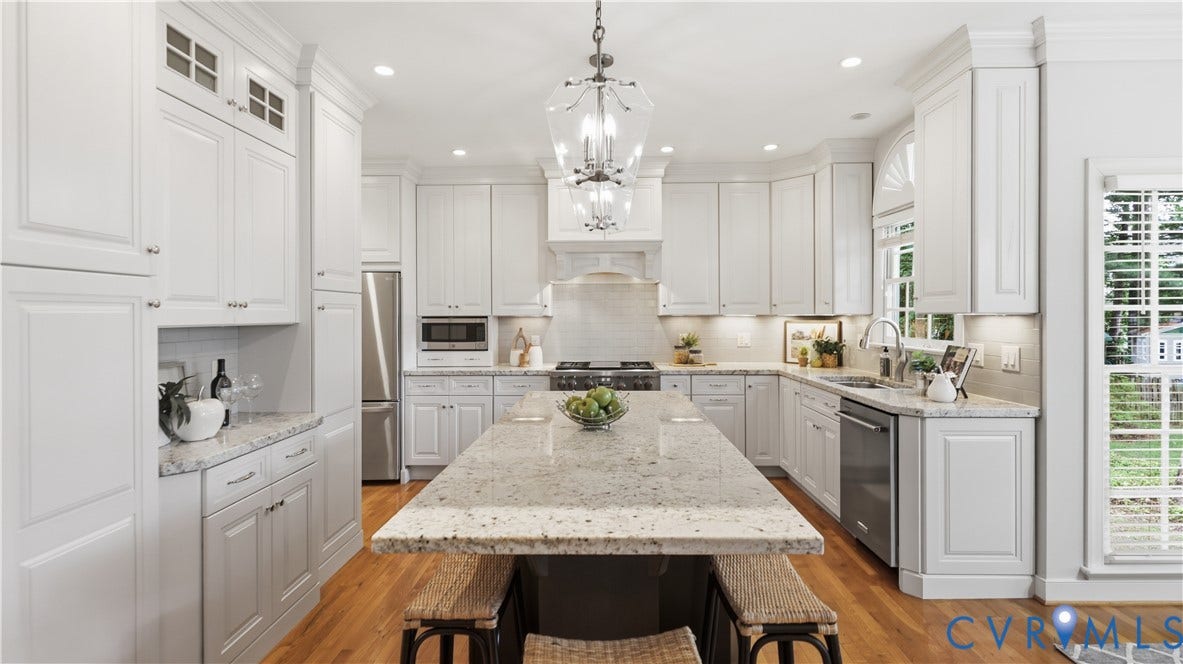 12400 Chadsworth Place, Wyndham, Glen Allen, VA 23059 Well-appointed kitchen featuring a substantial island with stone countertops, extensive white cabinetry, stainless steel appliances, and wood-finish flooring