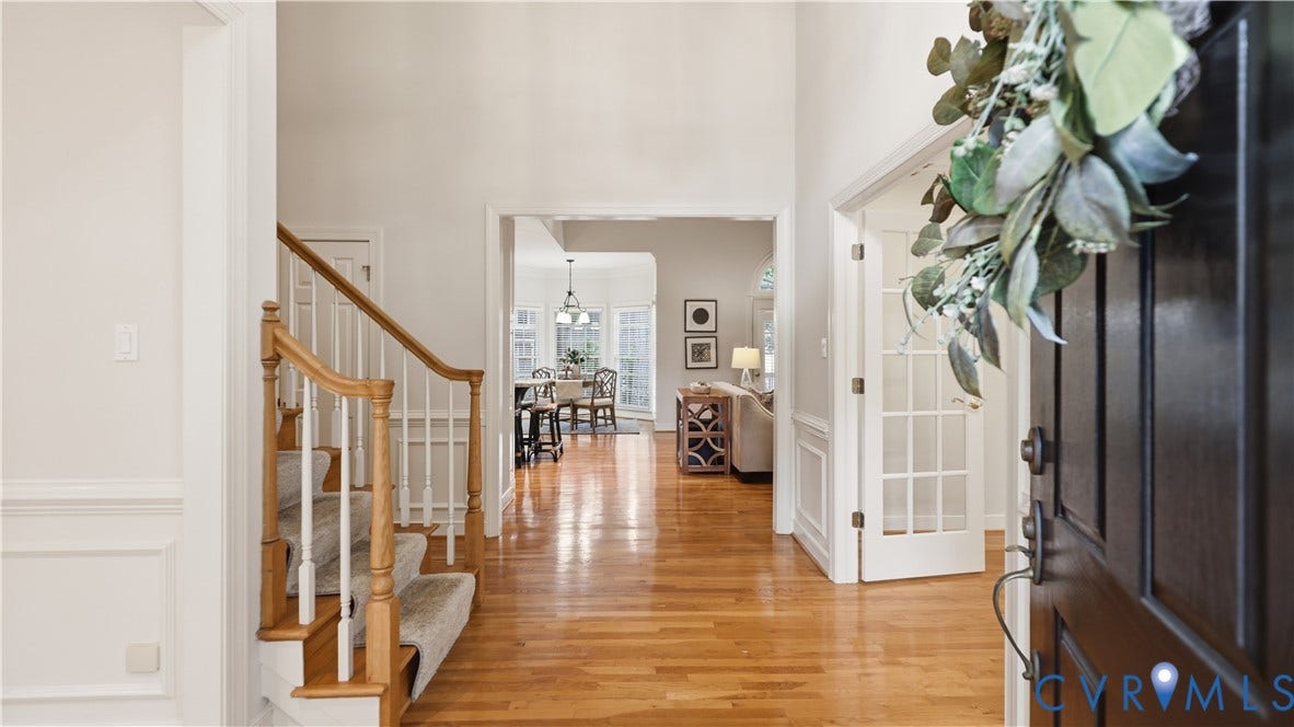 12400 Chadsworth Place, Wyndham, Glen Allen, VA 23059 Entry foyer featuring wood-finish flooring, a carpeted staircase with wood handrails and white balusters, and transom archways