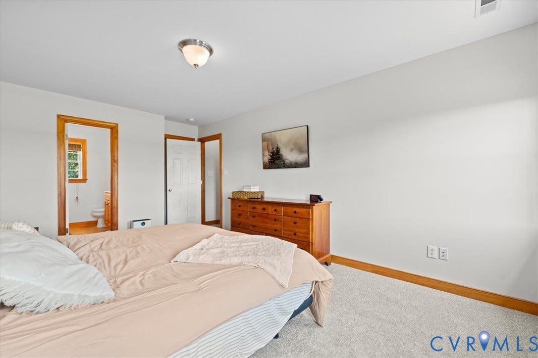 Primary bedroom Bright room with neutral wall tones and plush carpet flooring