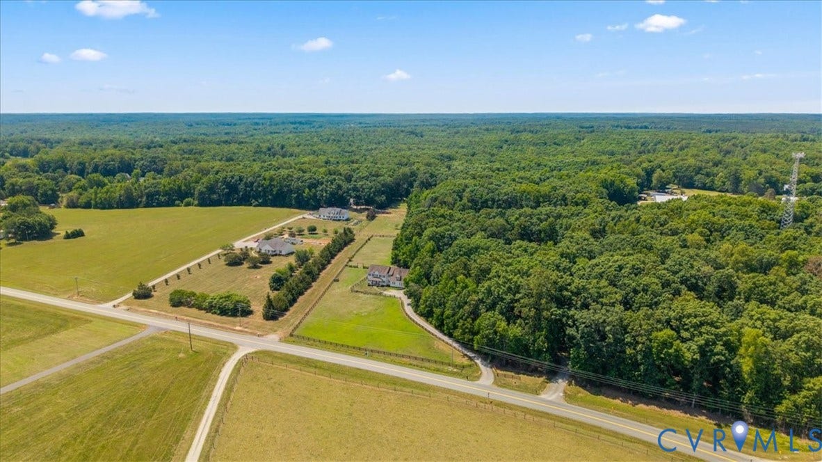Expansive rural landscape featuring a mix of cleared fields and mature woodlands